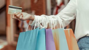 femme avec carte de crédit a la main et sac de shopping